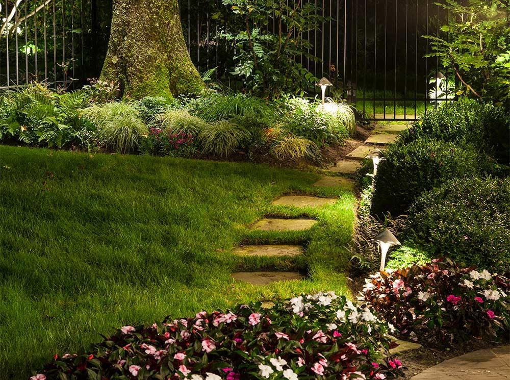 lit-floral-and-grass-pathway-at-night