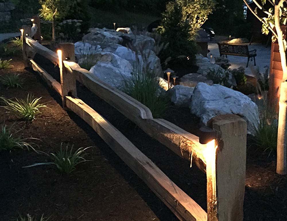 CAST Craftsman Series Bronze Deck Lights mounted to a fence