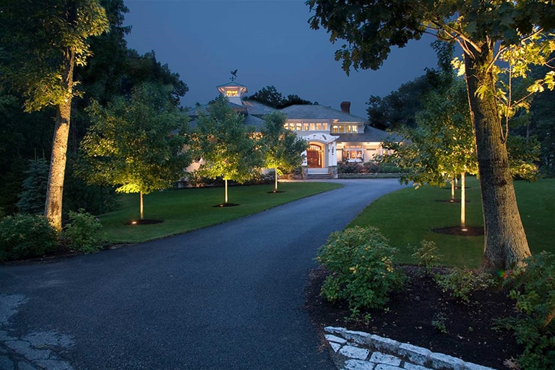 Front driveway and yard at night lit by CAST Landscape lights.