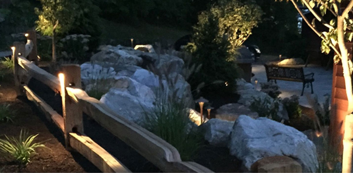 Fence posts with lights along the perimeter of a backyard.