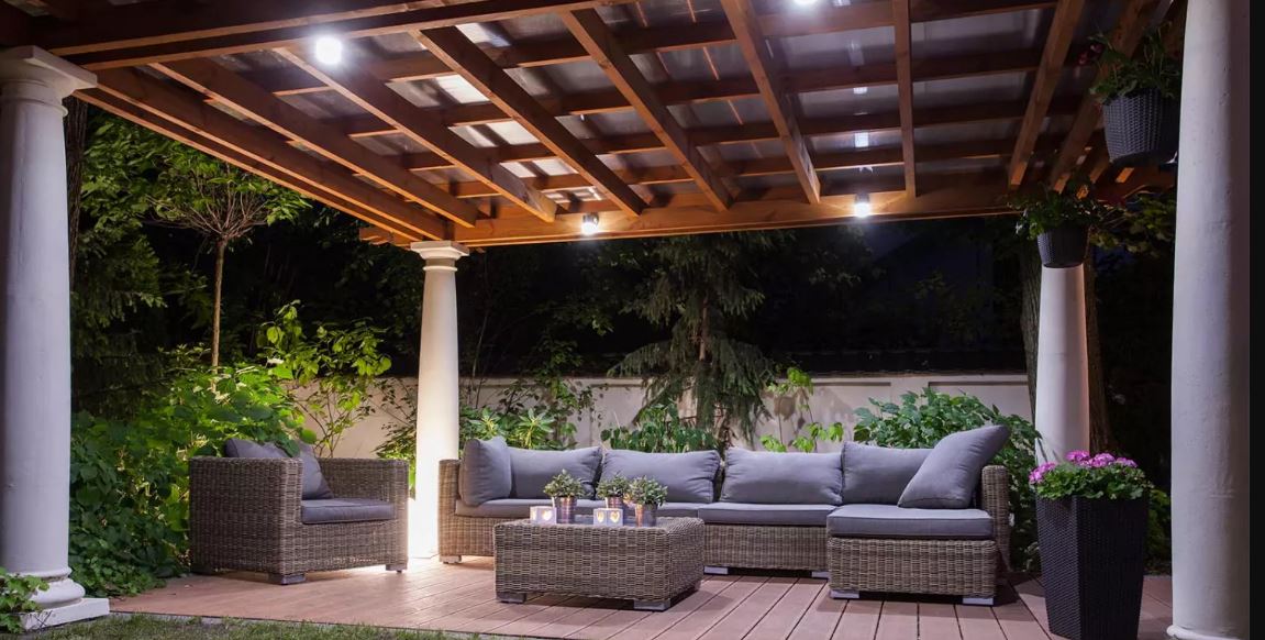 Simple overhead lights and a spotlight used to illuminate an outdoor patio area.