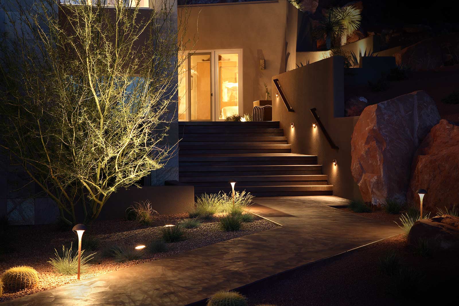 lights leading up front patio pathway and staircase at night