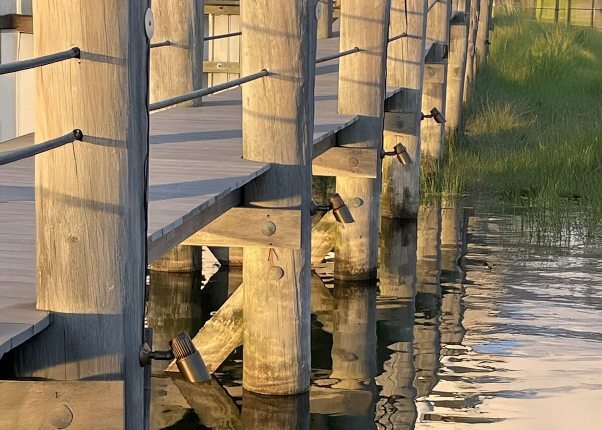 bullet lights pointing into the water from the dock during the daytime