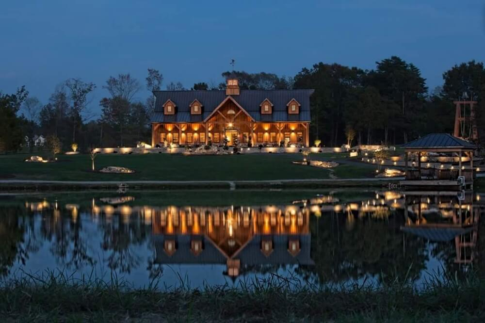 the back of a clubhouse on the late that has the landscaping and exterior illuminated